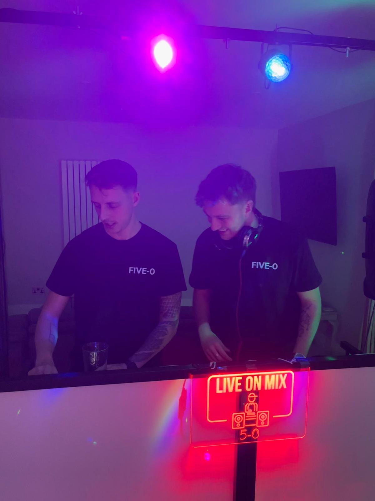 Five-O DJs behind the decks with purple lighting